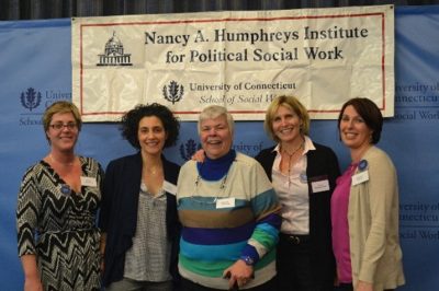 Nancy A. Humphreys with colleagues in front of a sign for the Institute