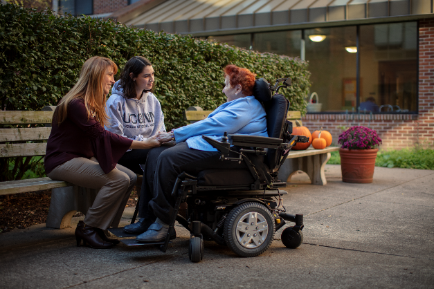 Elderly woman in wheelchair with students